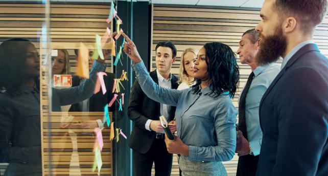 People strategizing on a board